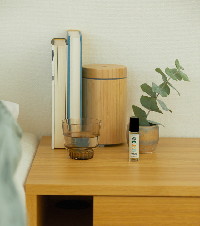 Bedroom side table with Euka Molecular Helmet, a glass of water and books